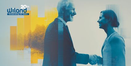 A man and a woman shake hands, symbolizing collaboration, set against a modern, abstract background with vibrant colors and textures