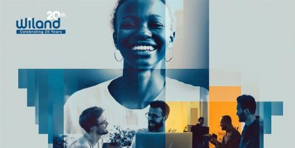 A collage saying 'Wiland's 20th anniversary' upper left corner, with individuals engaged in collaborative work in a modern office setting.