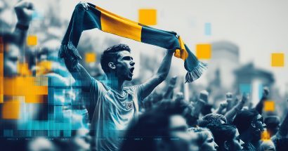 A fan standing up in the stands of a sporting event, waving a scarf of his team's colors