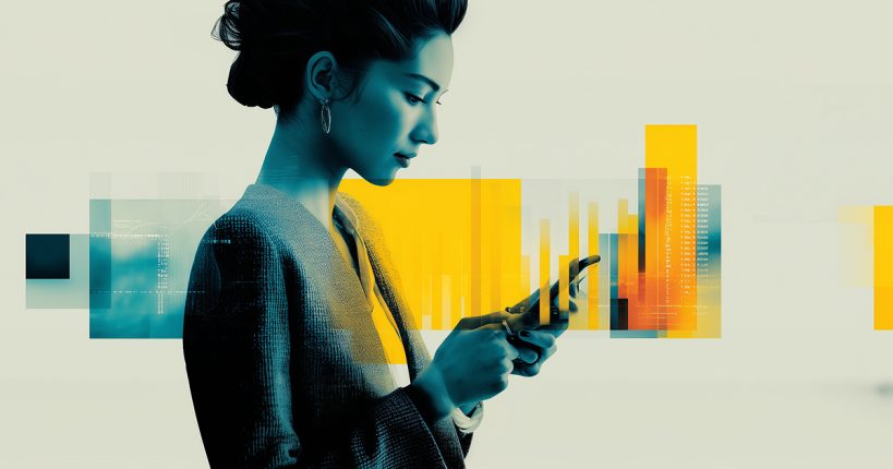 A woman in a casual business suit checks a notification on her phone.